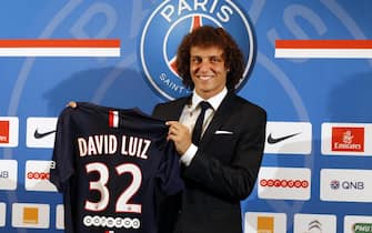 epa04344054 Brazilian player David Luiz (R) holds up his Paris Saint Germain jersey after he gave a press conference, on his official presentation as a new player for the Paris Saint Germain (PSG) soccer team in Paris, France, 07 August 2014.  EPA/ETIENNE LAURENT