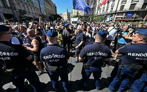 Police officers face participants of the Budapest Pride march, on June 28, 2025 in Budapest. Hungary's Prime Minister had announced that police will not "break up" Saturday's Budapest Pride march despite issuing a ban, but warned attendees and organisers about the legal consequences. His ruling coalition amended laws and the constitution earlier this year to prohibit the annual celebration, advancing his widely condemned, years-long clampdown on LGBTQ rights in the name of "child protection". (Photo by Attila KISBENEDEK / AFP)