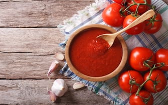 tomato sauce with garlic and basil in a wooden bowl. horizontal view from above
