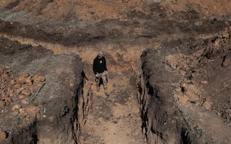 epa11215100 A man walks in a trench as workers build a fortification line at an undisclosed location in the Zaporizhzhia region, Ukraine, 11 March 2024, amid the Russian invasion. Ukraine began to build huge defense lines protecting 2,000 kilometers near the frontline, as confirmed by Ukrainian President Volodymyr Zelensky following a High Command General Headquarters sitting on 11 March.  EPA/KATERYNA KLOCHKO