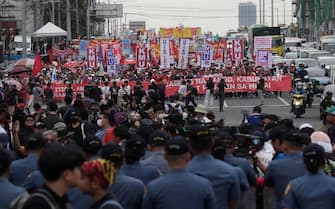 epa10765319 Filipino policemen stand guard to block marching activists during a protest rally along a road leading to the Congress compound in Quezon city, Metro Manila, Philippines, 24 July 2023. The protesters gathered against the State of the Nation Address (SONA) of President Ferdinand 'Bongbong' Marcos.  EPA/FRANCIS R. MALASIG