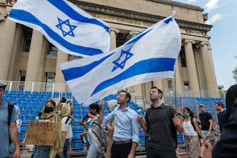 NEW YORK, NEW YORK - APRIL 29:  Men wave an Israeli flag as pro-Palestinian supporters continue to demonstrate from a protest encampment on the campus of Columbia University on April 29, 2024 in New York City. Columbia University issued a notice to the protesters asking them to disband their encampment after negotiations failed to come to a resolution.  (Photo by Spencer Platt/Getty Images)