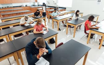 High school students and teenagers go back to school in the classroom at their high school. They are required to wear face masks and practice social distancing during the COVID-19 pandemic. They value their education and are excited to be in school. Image taken in Utah, USA.