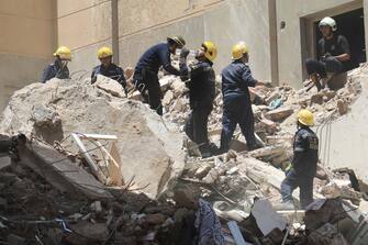 epa10711929 Civil defense personnel search for survivors amid the rubble of a collapsed 13-storey-building in Alexandria, Egypt, 26 June 2023. A number of the building residents are feared to be trapped beneath the rubble, however the exact number of people is yet to be known.  EPA/STR