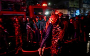 EDITORS NOTE: Graphic content / A firefighter carries an injured person during rescue operations following a fire in a commercial building that killed at least 43 people, in Dhaka, on February 29, 2024. At least 43 people were killed and dozens injured after a fire blazed through a seven-storey building in an upscale neighbourhood in the Bangladeshi capital of Dhaka late on February 29, health authorities said. (Photo by Munir Uz Zaman / AFP) (Photo by MUNIR UZ ZAMAN/AFP via Getty Images)