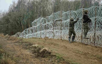 Polish Army soldiers construct a razor wire fence along the Polish border, with the Russian enclave of Kaliningrad, near Zerdziny, Poland, on Saturday, Nov. 5, 2022. The Baltic region of Kaliningrad, cut off from the rest of Russia after the independence of the Baltic states in 1990, was in German hands for centuries until it was seized and annexed by the Soviet Union in 1945. Photographer: Damian Lemankski/Bloomberg