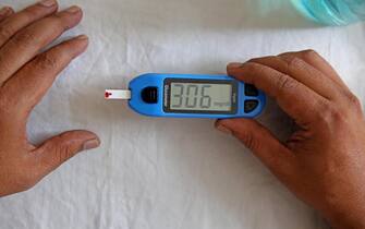 epa09581249 A health official checks the sugar level reading of a person during free diabetes awareness camp on the occasion of 'World Diabetes Day' in Bangalore, India, 14 November 2021. The walk was aimed to create awareness about diabetes and free access to diabetes care and prevention. 14 November is observed as World Diabetes Day.  EPA/JAGADEESH NV