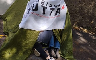 Alcuni studenti dentro una tenda da campeggio hanno montato dei cartelli di protesta contro il caro affitti  davanti al Mur a Roma, 11 maggio 2023.
ANSA/Cecilia Ferrara