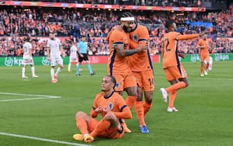 Netherlands' midfielder #07 Xavi Simons (C down) celebrates after scoring his team's opening goal during the International friendly football match between Netherlands and Iceland at the Feyenoord Stadium, in Rotterdam, on June 10, 2024. (Photo by JOHN THYS / AFP)