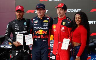 CIRCUIT OF THE AMERICAS, UNITED STATES OF AMERICA - OCTOBER 21: Sir Lewis Hamilton, Mercedes-AMG, 2nd position, Max Verstappen, Red Bull Racing, 1st position, and Charles Leclerc, Scuderia Ferrari, 3rd position, are presented with their trophies by US track and field star Sha'Carri Richardson, after the Sprint race during the United States GP at Circuit of the Americas on Saturday October 21, 2023 in Austin, United States of America. (Photo by Glenn Dunbar / LAT Images)