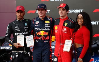 CIRCUIT OF THE AMERICAS, UNITED STATES OF AMERICA - OCTOBER 21: Sir Lewis Hamilton, Mercedes-AMG, 2nd position, Max Verstappen, Red Bull Racing, 1st position, and Charles Leclerc, Scuderia Ferrari, 3rd position, are presented with their trophies by US track and field star Sha'Carri Richardson, after the Sprint race during the United States GP at Circuit of the Americas on Saturday October 21, 2023 in Austin, United States of America. (Photo by Glenn Dunbar / LAT Images)