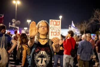 A left-wing protester holds a sign saying "A massacre never justifies a massacre" at a demonstration for a hostage deal near the Knesset, on March 31, 2024, in Jerusalemm Israel. (Photo by Yahel Gazit / Middle East Images / Middle East Images via AFP) (Photo by YAHEL GAZIT/Middle East Images/AFP via Getty Images)