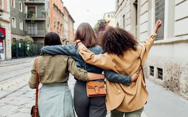 Three multiethnic woman outdoor fooling around having fun - Italy, Lombardy, Milan - diversity, social bubble, post normal concept