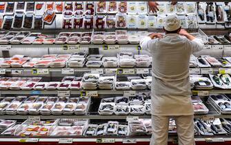 An employee restocks the fish section of an Esselunga supermarket in Milan's Famagosta district on April 30, 2020, during the country's lockdown aimed at curbing the spread of the COVID-19 infection, caused by the novel coronavirus. (Photo by Miguel MEDINA / AFP) (Photo by MIGUEL MEDINA/AFP via Getty Images)