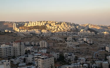 Bethlehem, West Bank, Palestine - 22 July 2022: Cityscape at Dusk with Last Sun Rays Over the White Stone Buildings