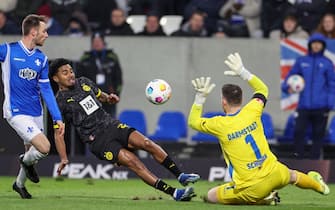 epa11074296 Dortmund's Ian Maatsen (C) in action against Darmstadt's goalkeeper Marcel Schuhen (R) during the German Bundesliga soccer match between SV Darmstadt 98 and Borussia Dortmund in Darmstadt, Germany, 13 January 2024.  EPA/CHRISTOPHER NEUNDORF CONDITIONS - ATTENTION: The DFL regulations prohibit any use of photographs as image sequences and/or quasi-video.
