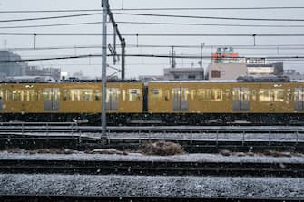 A train is passing during the first snowfall of the year in Tokyo, Japan, on February 5, 2024. (Photo by Jerome Gilles/NurPhoto via Getty Images)