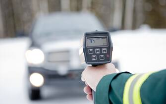 An enforcement officer using a speed radar gun