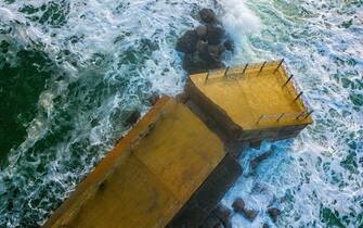 Aerial view of a pier with rocks. Pizzo Calabro pier. Broken pier, force of the sea. Natural disasters, climate change. Calabria, Italy