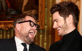 LONDON, ENGLAND - FEBRUARY 18: Actors Andrew Garfield (R) and James Corden react, on the day Britain's Queen Camilla attends a reception for staff, actors and supporters of the National Theatre at Buckingham Palace on February 18, 2025 in London, England. (Photo by Isabel Infantes - WPA Pool/Getty Images)