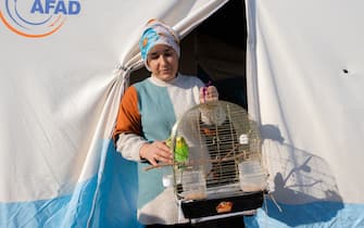 KAHRAMANMARAS, TURKIYE - FEBRUARY 24: Hacer Yuce, an earthquake survivor lives the tent city established in Vali Saim Cotur Stadium and around with her parakeet named "Ãimen" after 7.7 and 7.6 magnitude earthquakes hit multiple provinces of Turkiye including Kahramanmaras on February 24, 2023. Some survivors of earthquakes in Kahramanmaras live together in a tent city with their animals, such as fish, birds, partridges, cats and dogs, which they rescued while leaving their homes. Established by the Sakarya 7th Commando Brigade Command, the tent city hosts nearly 3,500 earthquake victims as well as dozens of pets. (Photo by Fatih Kurt/Anadolu Agency via Getty Images)