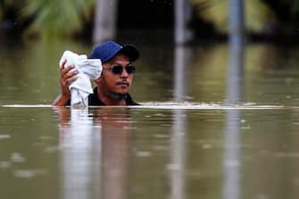 epa10501875 A man wades through a flooded area while raining in Yong Peng, Johor, Malaysia, 04 March 2023. According to state media, more than 33,000 people were evacuated in four states affected by the floods.  EPA/FAZRY ISMAIL