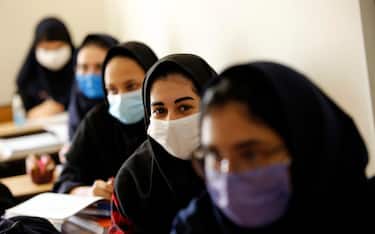 epa08648215 Iranian high school girls wearing face masks attend a class at the Bamdad Parsi private school during the first day of reopening schools, north of Tehran, Iran, 05 September 2020. Media reported that school reopened in Iran during the coronavirus crises in the country.  EPA/ABEDIN TAHERKENAREH