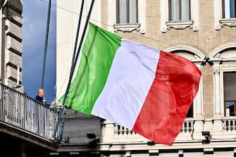 Un dipendente di Palazzo Chigi issa la bandiera a mezz asta, durante il Consiglio dei ministri, Roma, 25 Settembre 2023. ANSA/ALESSANDRO DI MEO