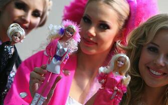 NUREMBERG, GERMANY - FEBRUARY 04:  Models pose for the media presenting different  Barbie dolls at the trade-show booth of toy producer "Mattel" during a press preview prior to  the opening of the 60th edition of Nuremberg's toy fair on February 4, 2009 in Nuremberg, Germany. Approximately  2700 exhibitors of 60 countries present their products during the International toy fair running from February  5 to 10, 2009.  (Photo by Miguel Villagran/Getty Images)