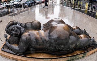 epa10356506 Fish eye lens photo of a view of the sculpture 'Woman with a Mirror', by Colombian artist Fernando Botero, during a rainfall in Madrid Spain, 09 December 2022. Rainfalls are hitting the capital city during the day.  EPA/FERNANDO VILLAR