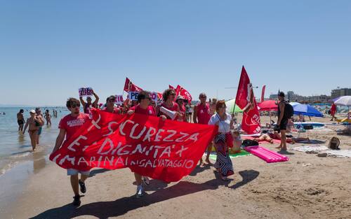 Sciopero simbolico dei bagnini oggi lungo il litorale della provincia di Rimini, dove i lavoratori del servizio di salvataggio hanno protestato per chiedere condizioni lavorative più eque. Al centro della mobilitazione, la richiesta di turni più sostenibili, nuove assunzioni e un servizio di salvataggio strutturato in maniera più sicura ed efficiente.

La protesta, indetta nel pieno della stagione estiva, non ha comportato interruzioni del servizio: grazie alla precettazione disposta dalla Prefettura, i bagnini hanno comunque garantito la sorveglianza in torretta, mentre la manifestazione si è svolta in forma ordinata.

Il corteo è partito intorno alle 12.30 dalla zona dei bagni 36-37 di Rimini, snodandosi lungo il litorale fino a raggiungere il piazzale Boscovich. Nessun disagio segnalato per i turisti presenti in spiaggia. Rimini, 9 agosto 2025. ANSA/Ph Dorin Mihai, Pasquale Bove

____

EN:

Italy: Rimini lifeguards hold symbolic strike, no impact on beach safety. Prefect orders mandatory service

RIMINI, Italy, Aug 9 (ANSA) – Lifeguards along Rimini’s coastline staged a symbolic strike on Saturday to protest working conditions during the peak summer season. The workers are demanding more manageable shift schedules, additional personnel, and improved safety protocols for rescue operations.

Despite the strike announcement, no disruption to beach safety was reported. Under an order issued by the Prefect, lifeguards were required to remain at their posts, ensuring continuous coverage of the shoreline.

The demonstration, which unfolded without incident, included a peaceful march beginning at 12:30 p.m. near Rimini bathing areas 36–37 and proceeding along the seafront to Piazzale Boscovich. Tourists and beachgoers were largely unaffected. Rimini (Italy) august 9 2025, ANSA/Ph Dorin Mihai, Pasquale Bove
