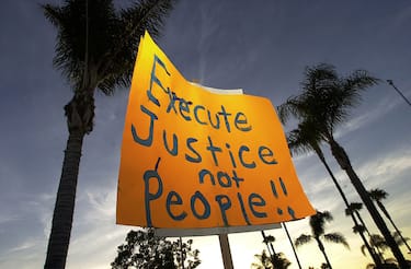 390763 02: A protester holds a sign up against a backdrop of palm trees during an anti-death penalty protest on the eve of the second federal execution in nearly four decades June 18,2001 in Santa Ana, CA. Juan Garza, who was sentenced to death by a judge who believes that the death penalty is morally wrong, is scheduled to die a week after the killing of Oklahoma bomber Timothy McVeigh in Terra Haut, ID. (Photo by David McNew/Getty Images)