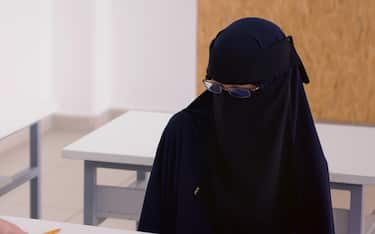 Male professor of architecture explain lesson to muslim female student wearing niqab and interact with her in the modern classroom.Helping a students