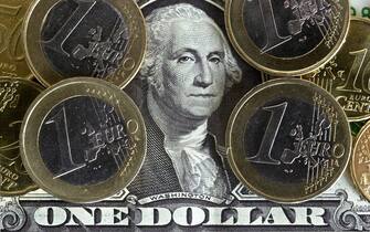Una banconota da un dollaro e delle monete da un euro