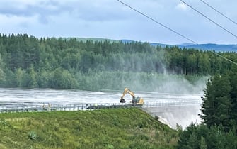 Workers reinforce the dam in Braskereidfoss in Valer to prevent it from bursting after floodgates did not work properly, on August 9, 2023. (Photo by BÃ¥rd Langvandslien / NTB / AFP) / Norway OUT (Photo by BARD LANGVANDSLIEN/NTB/AFP via Getty Images)