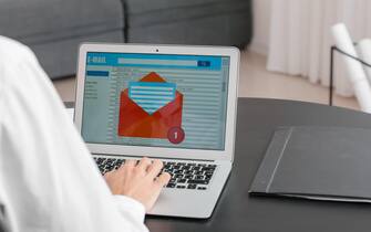 Young man with laptop checking his e-mail in office