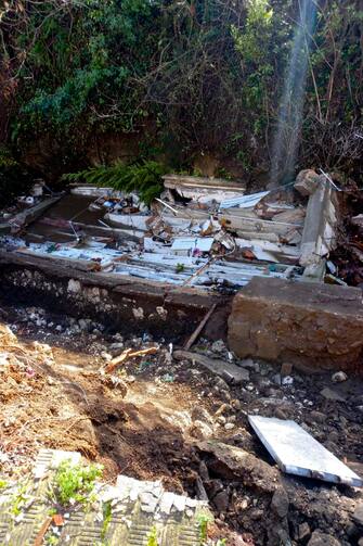 Una ventina di bare e 80 urne sono finite in un torrente in seguito al cedimento di un'ala del cimitero. È accaduto a S. Agata dei Goti, in provincia di Benevento, 19 gennaio 2023. 
ANSA