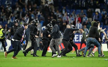 BARCELONA, SPAIN - MAY 14: Police and RCD Espanyol fans are seen on the pitch after the LaLiga Santander match between RCD Espanyol and FC Barcelona at RCDE Stadium on May 14, 2023 in Barcelona, Spain. (Photo by David Ramos/Getty Images)