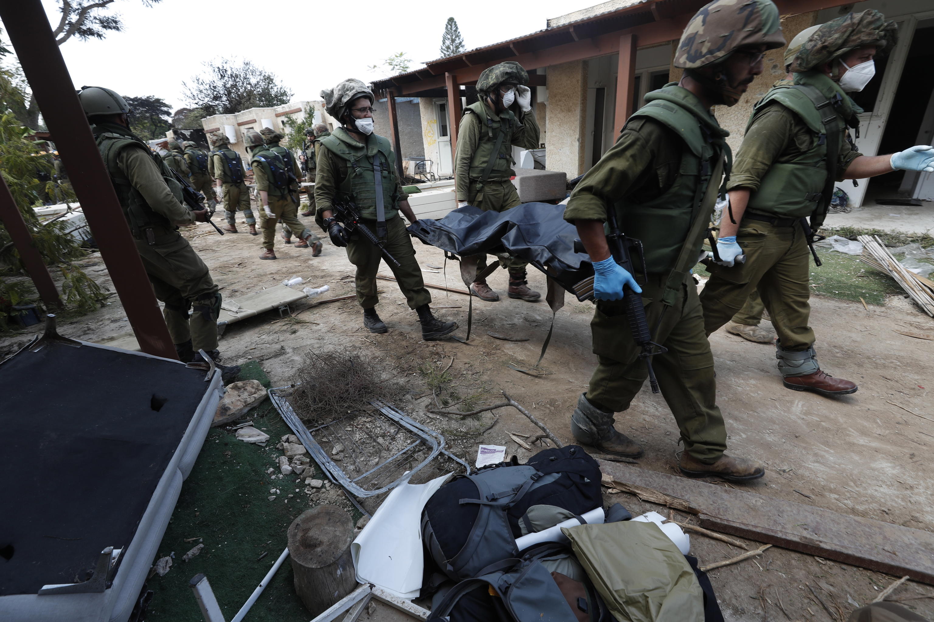 epa10911391 Israeli soldiers take the bodies of Israelis killed in Kfar Aza kibbutz near the border with Gaza, 10 October 2023. More than 900 people have been killed, around 150 were taken as hostages, and 1,500 others injured, according to Israel Defence Forces (IDF), after the Islamist movement Hamas launched an attack against Israel on 07 October. More than 3,000 people, including 1,500 militants from Hamas, have been killed and thousands injured in Gaza and Israel since 07 October, according to Israeli military sources and Palestinian officials.  EPA/ATEF SAFADI