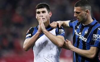 epa09782324 Atalanta's player Ruslan Malinovskyi (L) celebrates showing a shirt with a 'No war in Ukraine' lettering after scoring a goal during the UEFA Europa League play-off second leg soccer match Olympiacos vs Atalanta held at G. Karai?skakis Stadium in Piraeus, Greece, 24 February 2022.  EPA/GEORGIA PANAGOPOULOU