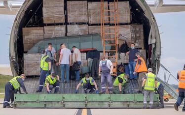 epa08438311 Ramp workers offload an Antonov AN-124 cargo plane, after it arrived with 13 million KN95 face masks at Hartsfield-Jackson Atlanta International Airport in Atlanta, Georgia, USA, 22 May 2020. The global supply chain operator GEODIS contracted the shipment of 13 million masks from China to provide additional personal protective equipment (PPE) in the metro Atlanta area during the coronavirus COVID-19 pandemic.  EPA/ERIK S. LESSER