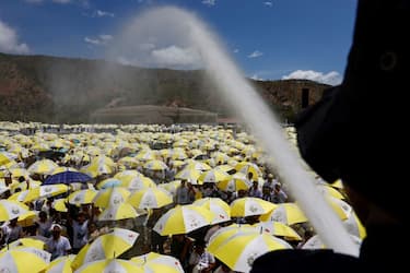 A firefighter sprays water on Catholic faithful gathered for a holy mass with Pope Francis at the Esplanade of Tacitolu park in Dili, East Timor on September 10, 2024. (Photo by Willy Kurniawan / POOL / AFP) (Photo by WILLY KURNIAWAN/POOL/AFP via Getty Images)