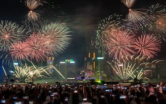 People are watching fireworks explode over Victoria Harbour to mark the arrival of the year 2024 in Hong Kong, China, on January 1, 2024. (Photo by Vernon Yuen/NurPhoto)