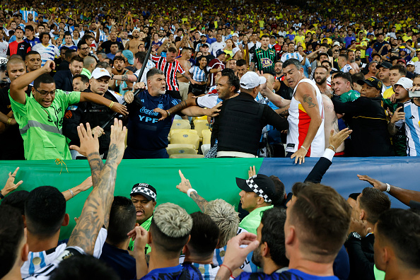 RIO DE JANEIRO, BRAZIL - NOVEMBER 21: Rodrigo De Paul of Argentina and teammates react as police officers clash with fans prior to a FIFA World Cup 2026 Qualifier match between Brazil and Argentina at Maracana Stadium on November 21, 2023 in Rio de Janeiro, Brazil. The match was delayed due to incidents in the stands. (Photo by Wagner Meier/Getty Images)