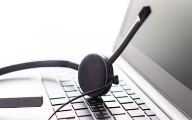 Help desk, customer service, support hotline or call center concept. Close up of headset on laptop keyboard. Video call conference or telemarketing.