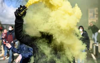 A protester uses  a flare during a demonstration after the French government pushed a pensions reform through parliament without a vote, using the article 49.3 of the constitution, in Nantes, western France, on March 18, 2023. The French president on March 16 rammed a controversial pension reform through parliament without a vote, deploying a rarely used constitutional power that risks inflaming protests. The move was an admission that his government lacked a majority in the National Assembly to pass the legislation to raise the retirement age from 62 to 64.//SALOM-GOMIS_n002/Credit:Sebastien SALOM-GOMIS/SIPA/2303182020