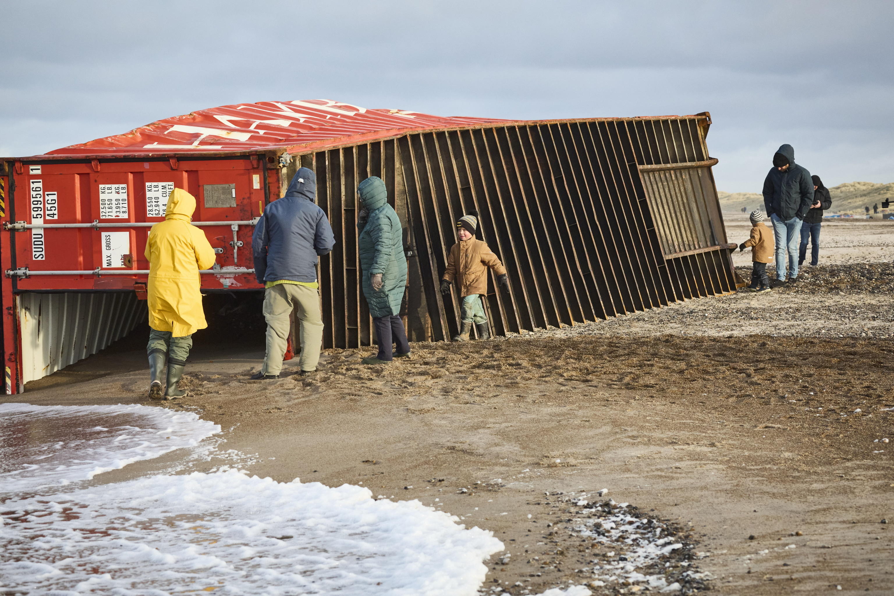 epa11044605 Locals inspect items from containers spillage  along the West coast at Tranum beach in North Jutland, Denmark, 26 December 2023. The contents of 46 lost containers from the ship Mayview Maersk wash ashore in North Jutland. The containers washed overboard during storm Pia.  EPA/Claus Bjoern Larsen  DENMARK OUT