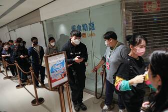 epa10404089 People line up to claim free return ferry tickets to Macau at a ferry terminal in Hong Kong, China, 14 January 2023. Hundreds of people queued up to take advantage of a tourism campaign called 'Macau Treat' to revive tourism in Macau, which will see the Macau government reimburse visitors with a free return ride on buses or ferries on the condition that they stay in the city for at least one night from 14 January to 31 March 2023.  EPA/JEROME FAVRE