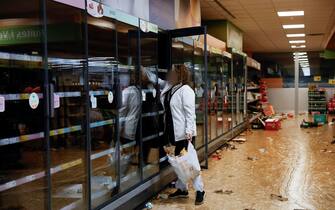 epa11693930 A resident collects items from a supermarket in the flood-hit municipality of Paiporta, in the province of Valencia, Spain, 31 October 2024.  At least 95 people died in the province of Valencia and neighboring provinces following floods caused by the DANA (high-altitude isolated depression) phenomenon impacting the eastern part of the country.  EPA/BIEL ALINO