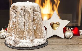 A spectacular pandoro covered with sugar prepared in front of the fireplace, ready to be eaten on Christmas day as tradition dictates